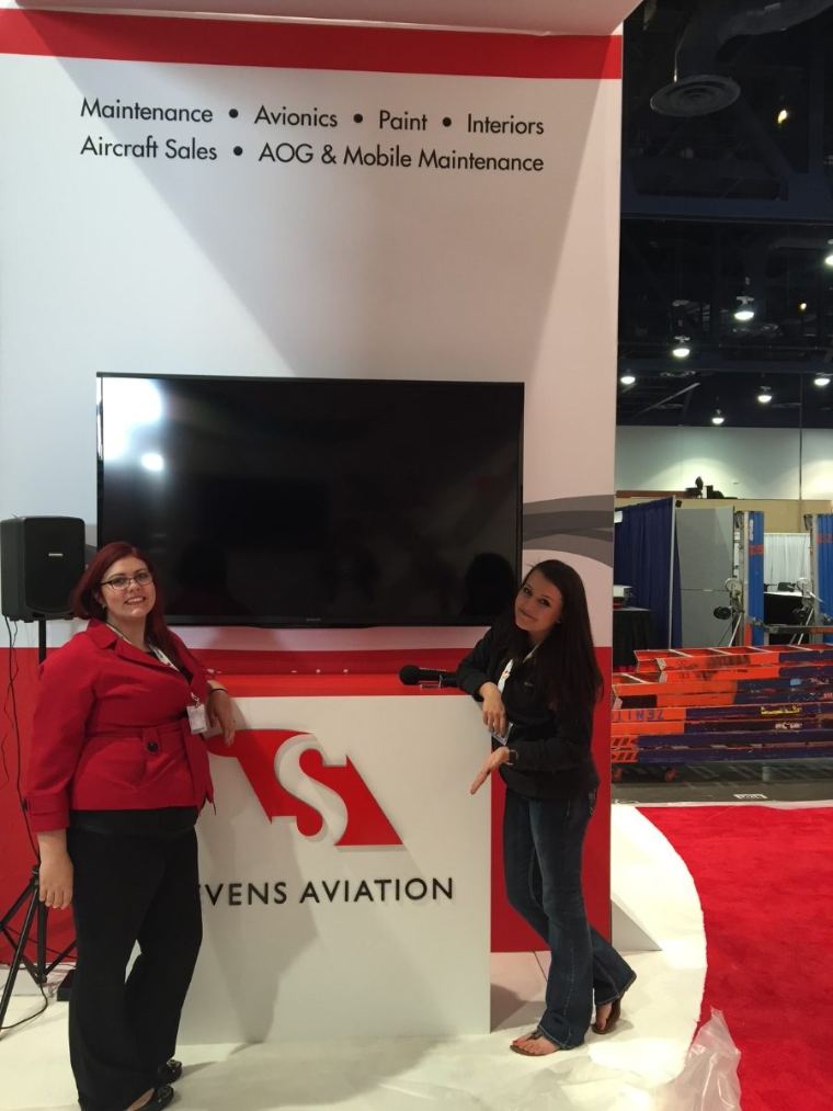 Emily with a colleague at the Stevens Aviation trade show booth