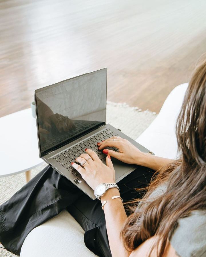 Hands typing on a laptop