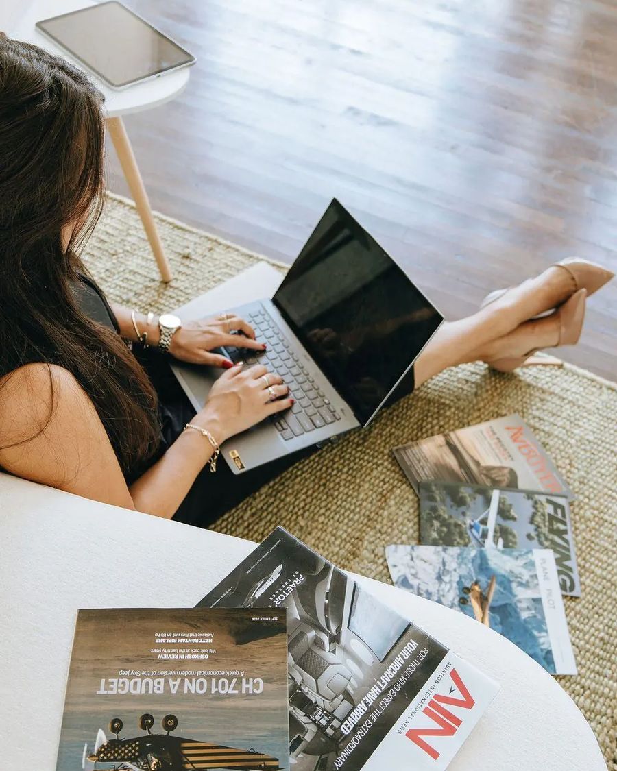 Overhead view of a laptop surrounded by aviation magazines