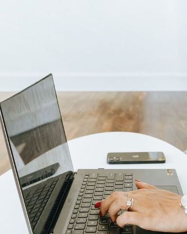 Hands on a laptop keyboard with a coffee mug nearby