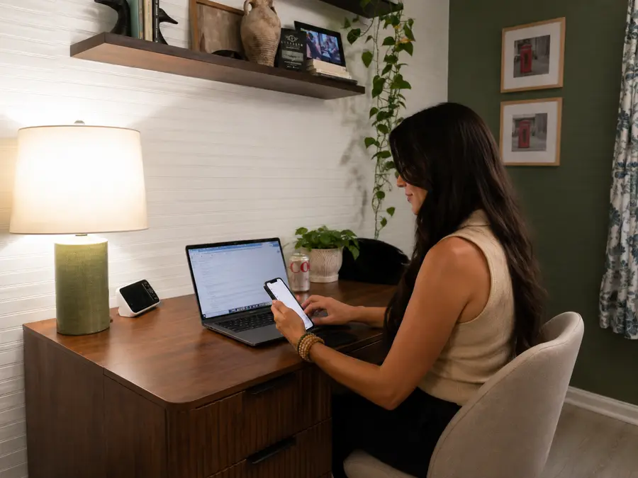 Emily working at a desk with a laptop and phone